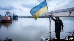 FILE - A sailor fixes the flag of Ukraine on a boat in Izmail, 700 km (432 miles) southwest of Kiev, Ukraine, on April 26, 2023. 