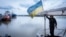 FILE - A sailor fixes the flag of Ukraine on a boat in Izmail, 700 km (432 miles) southwest of Kiev, Ukraine, on April 26, 2023. 