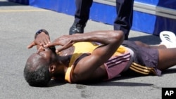 Ethiopian Sisay Lemma lies near the finish line and blows a kiss in celebration after winning the Boston Marathon on April 15, 2024 in Boston.