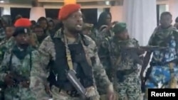 A man in military fatigues speaks as others stand behind him inside the Palace of the Nation during an attempted coup, in Kinshasa, Democratic Republic of Congo, May 19, 2024 in this screen grab from a social media video.