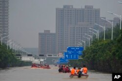 Tim penyelamat menggunakan perahu karet mengevakuasi warga yang terjebak melalui banjir di Zhuozhou di provinsi Hebei, China utara, selatan Beijing, Rabu, 2 Agustus 2023. (AP/Andy Wong)