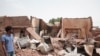 A man walks by a house hit in recent fighting in Khartoum, Sudan, April 25, 2023.