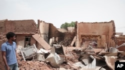 A man walks by a house hit in recent fighting in Khartoum, Sudan, April 25, 2023.