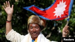 FILE - Nepali mountaineer Kami Rita Sherpa waves upon his arrival after climbing Mount Everest for the 24th time in 2019, setting a record for the most summits of the world's highest mountain, in Kathmandu, Nepal May 25, 2019.