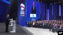 Russian President Vladimir Putin, left, delivers a speech at the United Russia party congress in Moscow, Dec. 17, 2023. (Mikhail Klimentyev, Sputnik, Kremlin Pool Photo via AP)