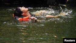 A man swims in a canal as temperatures hit a record 45.4° C (113.7° F) in Bangkok, Thailand, April 22, 2023.