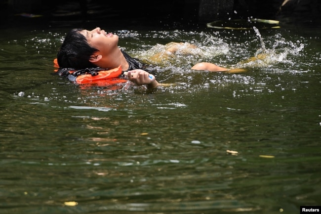 A man swims in a canal as temperatures hit a record 45.4° C (113.7° F) in Bangkok, Thailand, April 22, 2023.