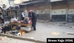 A man browses products at a stall on the Syrian government-controlled side of Palestinian Street in Hasaka, Syria, March 22, 2024.