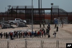 Migrants line up after being detained by U.S. authorities at the U.S.-Mexico border in Ciudad Juárez, Mexico, April 30, 2023.