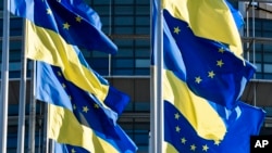 FILE - European Union and Ukraine flags fly outside the European Parliament, in Strasbourg, France, March 8, 2022.