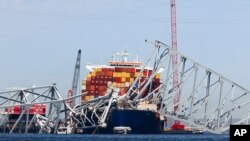 FILE - The collapsed Francis Scott Key Bridge lay on top of the container ship Dali, Monday, April 15, 2024, in Baltimore, Maryland. 