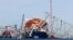 FILE - The collapsed Francis Scott Key Bridge lay on top of the container ship Dali, Monday, April 15, 2024, in Baltimore, Maryland. 