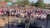 Un pastor ora por las víctimas de los disparos en Dadeville, Alabama, en una vigilia en el estacionamiento de la Primera Iglesia Bautista, el domingo 16 de abril de 2023. (Foto AP/Jeff Amy)