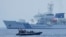 FILE - A Philippine Coast Guard rigid hull inflatable boat passes by the Japanese Coast Guard Akitsushima during a trilateral Coast Guard drill of the U.S., Japan and Philippines near the waters of the disputed South China See in Bataan province, Philippines, June 6, 2023.