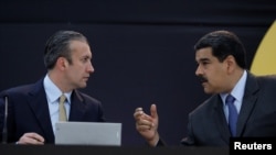 El hoy ex ministro de Petróleo de Venezuela, Tarek El Aissami, conversa con el presidente Nicolás Maduro durante un acto oficial de anuncios económicos, en febrero de 2018.