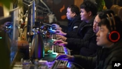 FILE - People play online games in an internet cafe in Fuyang in central China's Anhui provincey, March 1, 2019.