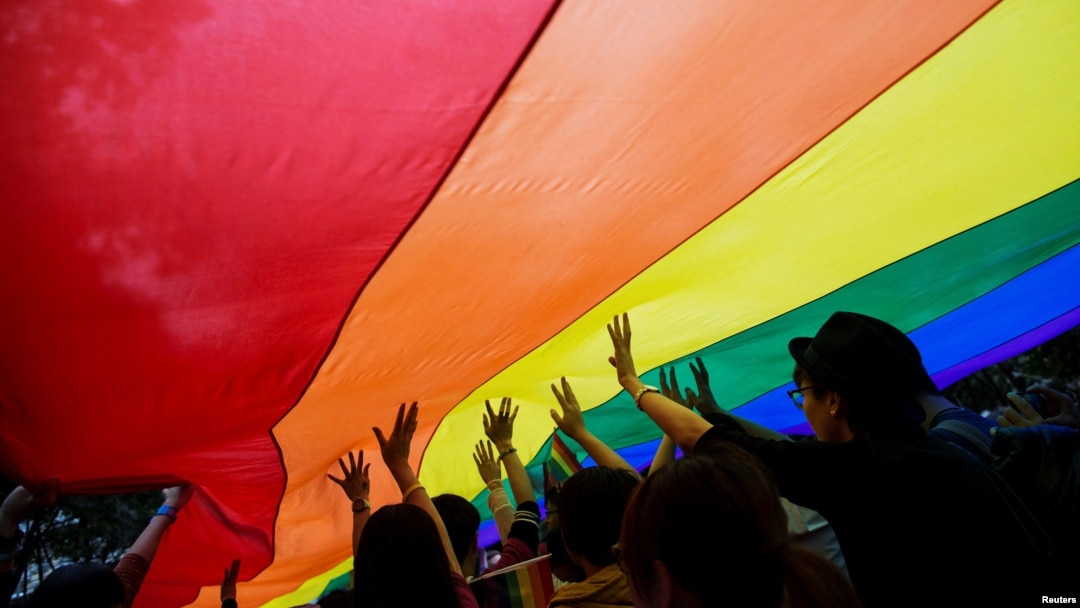 FILE - Participants hold a giant rainbow flag during an LGBTQ+ Pride Parade in Hong Kong on Nov. 8, 2014. Same-sex couples won an appeal on Oct. 24, 2023, on a ruling that grants them equal inheritance rights.