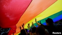 FILE - Participants hold a giant rainbow flag during a LGBTQ+ Pride Parade in Hong Kong on Nov. 8, 2014. Same-sex couples won an appeal on Oct. 24, 2023, on a ruling that grants them equal inheritance rights.