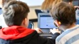 Michael Burton-Straub, left, and Declan Lewis attempt to "Find the Bot" in Donnie Piercey's class at Stonewall Elementary in Lexington, Ky., Monday, Feb. 6, 2023.  (AP Photo/Timothy D. Easley)