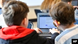 Michael Burton-Straub, left, and Declan Lewis attempt to "Find the Bot" in Donnie Piercey's class at Stonewall Elementary in Lexington, Ky., Monday, Feb. 6, 2023.  (AP Photo/Timothy D. Easley)