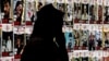 A person walks past posters of Israeli hostages held in Gaza since the October 7 attacks by Palestinian militants, during a protest by the families of the hostages and their supporters, in Tel Aviv on April 25, 2024.