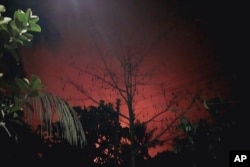 Api merah menyala keluar dari rumah-rumah yang terbakar di kota Buthidaung di negara bagian Rakhine, Myanmar, 17 Mei 2024. (Foto: AP)