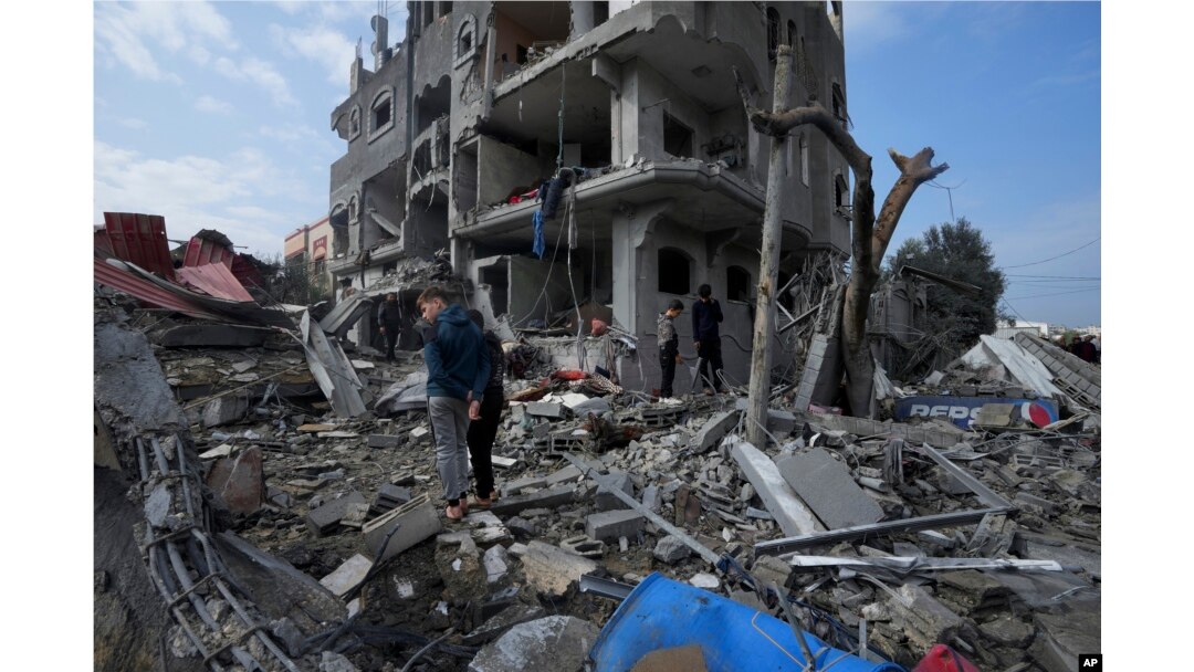Palestinians inspect the rubble of a building of the Al Nawasrah family destroyed in an Israeli strike in Maghazi refugee camp, central Gaza Strip, Dec. 25, 2023.