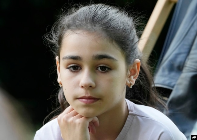 Milana Minenko, a 9-year-old child from Ukraine, glances to the side during an interview with The Associated Press, in Warsaw, Poland, Wednesday June 7, 2023. (AP Photo/Czarek Sokolowski)