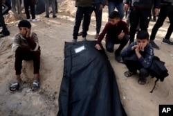 Palestinians mourn a relative killed in the Israeli bombardment of the Gaza Strip outside a morgue in Khan Younis, Jan. 22, 2024.