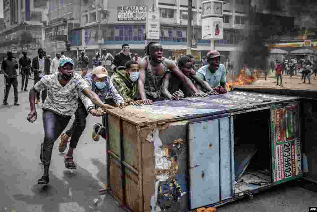 Protesters push a barricade during an anti-government demonstration called following nationwide deadly protests over tax hikes and a controversial now-withdrawn tax bill in downtown Nairobi, Kenya.