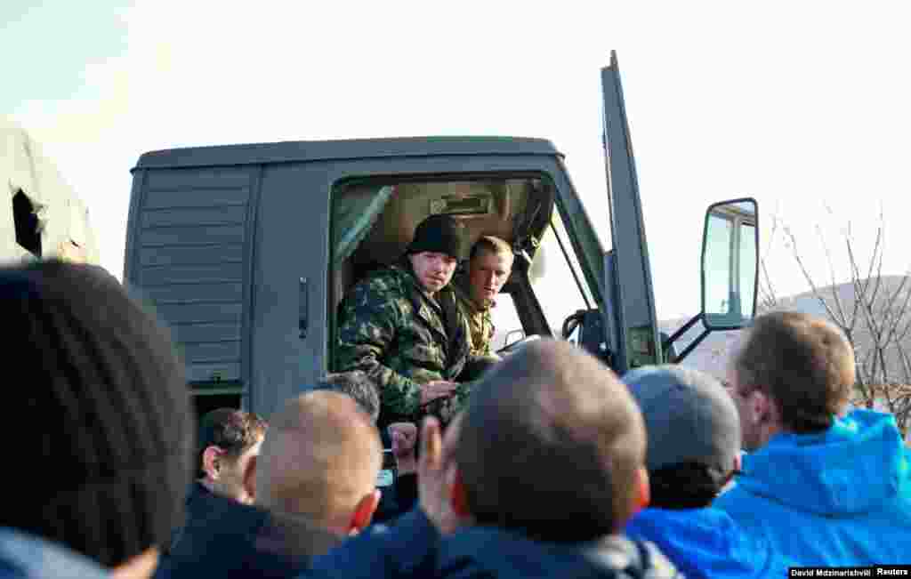 Los residentes locales rodean un camión conducido por soldados ucranianos el 3 de marzo. Un gran número de lugareños prorrusos en Crimea comenzaron a salir a las calles junto a soldados rusos sin identificación, lo que aumentó la presión sobre las tropas ucranianas que estaban cada vez más aisladas dentro de sus bases militares. Crimea en ese momento estaba poblada por alrededor del 60 por ciento de rusos étnicos.
