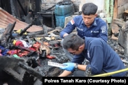 Polisi saat melakukan olah tempat kejadian perkara kasus kebakaran rumah jurnalis di Kabanjahe, Kabupaten Karo, Provinsi Sumatra Utara, 27 Juni 2024. (Foto: Polres Tanah Karo)