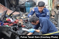 Polisi tengah berada di rumah jurnalis yang terbakar di Kabanjahe, Kabupaten Karo, Sumatera Utara, 27 Juni 2024. (Foto: Polres Tanah Karo)