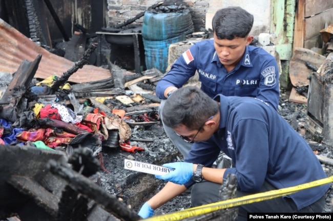 Polisi tengah berada di rumah jurnalis yang terbakar di Kabanjahe, Kabupaten Karo, Sumatera Utara, 27 Juni 2024. (Foto: Polres Tanah Karo)