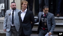 Daniel Penny, center, is walked by New York Police Department detectives out of the 5th Precinct on May 12, 2023, in New York. 