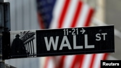 FILE - A sign for Wall Street outside the New York Stock Exchange in Manhattan in New York City, New York, Oct. 26, 2020. 