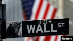 FILE - A sign for Wall Street outside the New York Stock Exchange in Manhattan in New York City, New York, Oct. 26, 2020. 