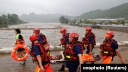 中国救援人员在北京门头沟区救助遭洪水泛滥袭击的民众。（2023年8月1日）