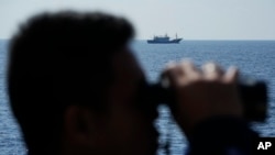 Terduga kapal militer milik China tampak berlayar menjauh setelah pasukan penjaga pantai Filipina BRP Malabrigo mengusirnya dari wilayah Filipina di Laut China Selatan pada 21 April 2023. (Foto: AP/Aaron Favila)