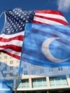 Flags fly during a rally for Uyghur citizens of China in Washington on Nov. 28, 2022.