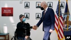 FILE - President Joe Biden shakes hands with veteran John Caruso at Fort Worth VA Clinic in Fort Worth, Texas, March 8, 2022. Biden on Aug. 10, 2022, signed veterans health care legislation that ended a long battle to expand benefits for people who served near burn pits.