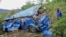 FILE - A man observes the wreckage at the scene of a bus crash involving dozens of mourners who were returning from a funeral, near Mwatate, in southern Kenya Sunday, April 16, 2023.