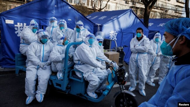FILE - Pandemic prevention workers leave for their shift to look after buildings where residents do home quarantine, as coronavirus disease (COVID-19) outbreaks continue in Beijing, Dec. 8, 2022.