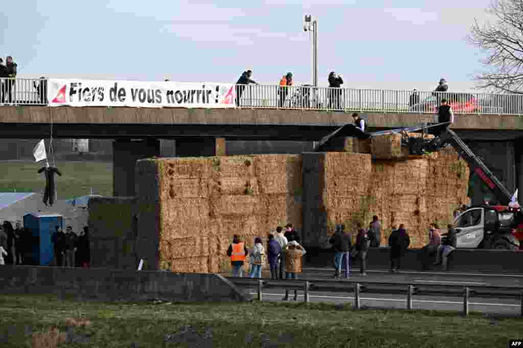 A banner reading &quot;Proud to feed you !&quot; is seen at a road blockage held by farmers on the A4 highway near Jossigny, east of Paris, amid nationwide protests called by several farmers unions on pay, tax and regulations.