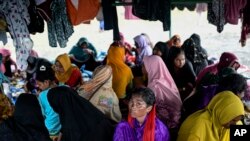 Ethnic Rohingya women take shelter under a tent near a beach where they landed on Dec. 10 in Pidie, Aceh province, Indonesia, Dec. 16, 2023. Since November, more than 1,500 Rohingya refugees fleeing Bangladesh by boat have landed in Indonesia’s northern province of Aceh.