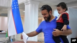 A voter in Uzbekistan casts a ballot in a referendum on a revised constitution, Tashkent, Uzbekistan, April 30, 2023. 
