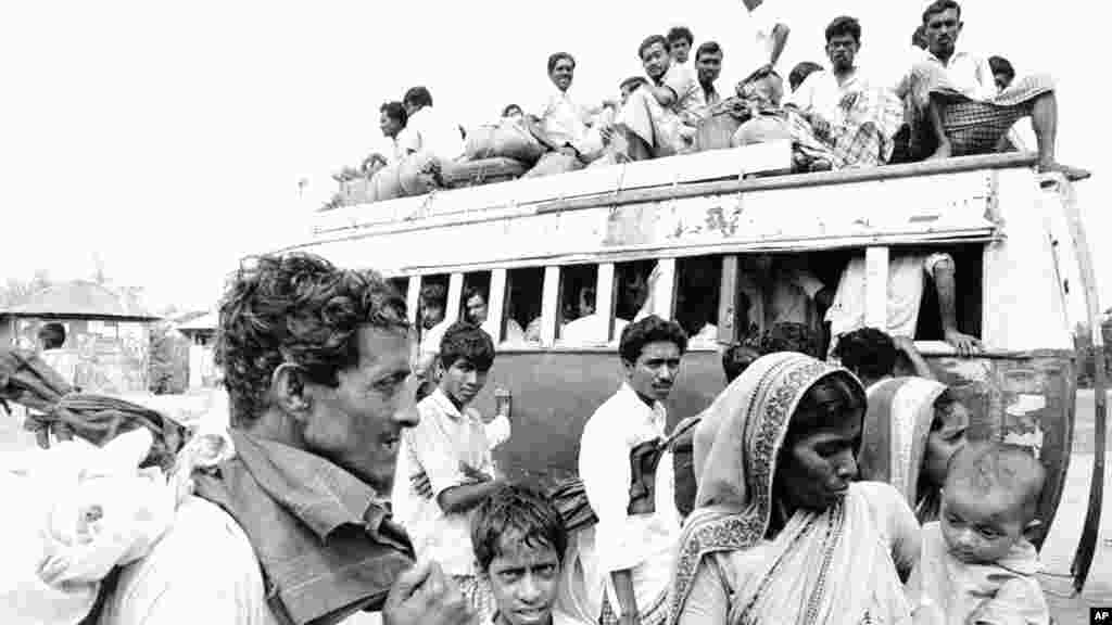 ১৯৭১ সালের ১১ এপ্রিল (ফাইল চিত্র)। বাঙালি শরণার্থীতে ঠাসা একটি বাস প্রস্তুতি নিচ্ছে ছাড়ার। ঢাকা এক শহরতলীতে এদের অনেকেই যাত্রার জন্য অপেক্ষমান।&nbsp;