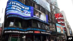 FILE - An electronic ticker displays news, March 11, 2020, in New York's Times Square.