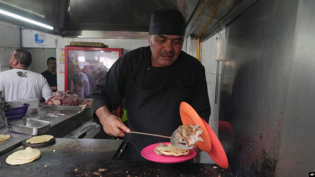 Newly minted Michelin-starred chef Arturo Rivera Martínez prepares an order of tacos at the Tacos El Califa de León taco stand in Mexico City, May 15, 2024.