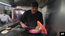 Newly minted Michelin-starred chef Arturo Rivera Martínez prepares an order of tacos at the Tacos El Califa de León taco stand in Mexico City, May 15, 2024.